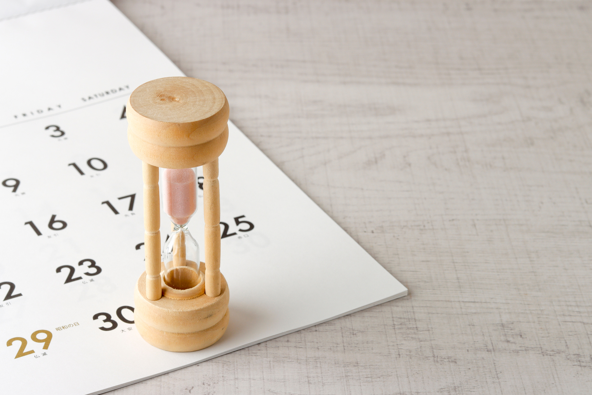 Wooden pink hourglass and calendar